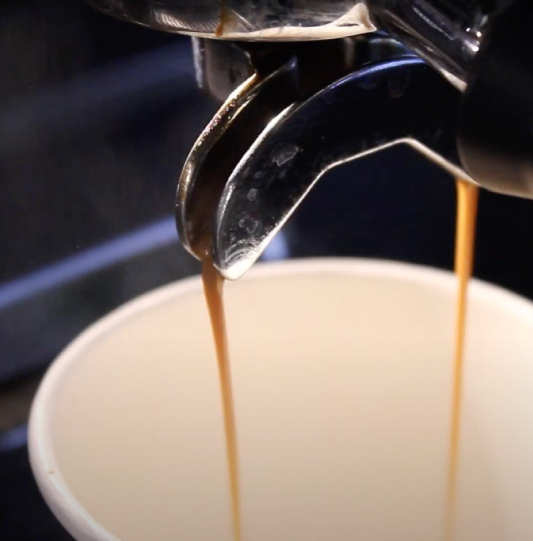 Coffee pouring from a machine into a disposable cup