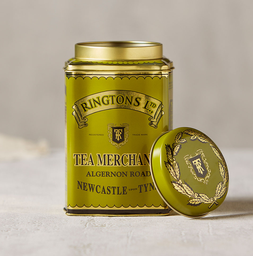 A green metal Ringtons tea caddy with the lid off