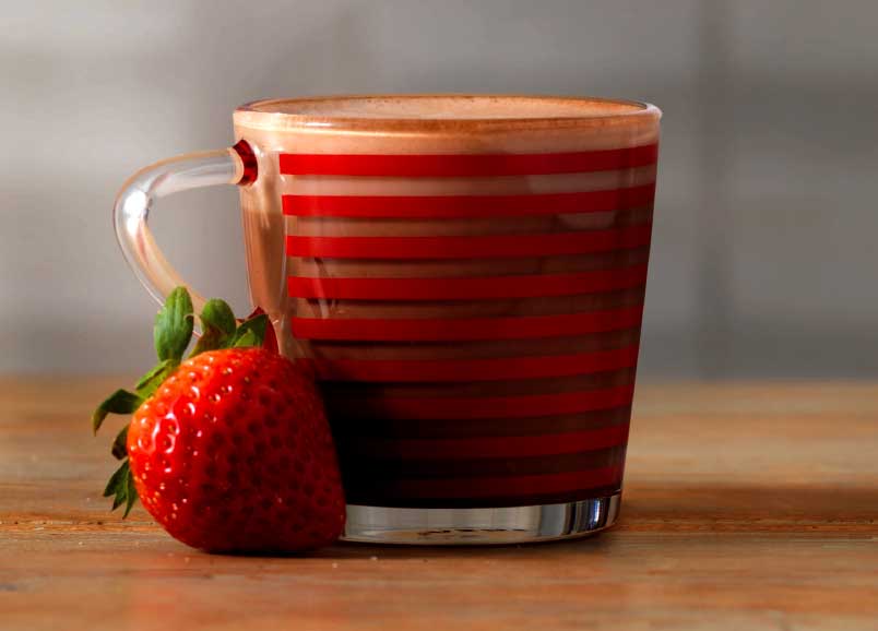 Strawberry hot chocolate with a strawberry next to it